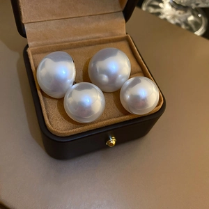 Close-up of large round white pearl earrings in a luxury jewelry gift box