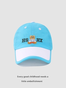 Detail of blue and white kids' baseball cap with cartoon bear and letter embroidery
