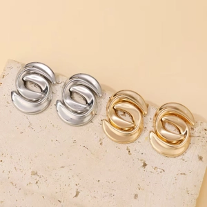 Detailed view of twisted metallic hoop earrings in polished gold and silver finishes