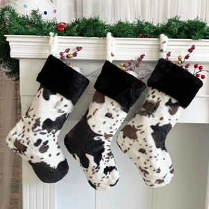 Close-up of three faux fur cow print Christmas stockings hanging on a white fireplace
