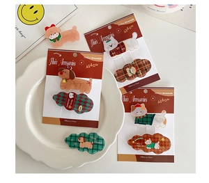 Detailed view of dog-shaped Christmas hair clips on a ceramic plate for girls