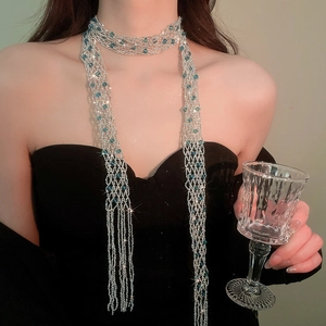 Close-up of a luxurious sparkling silver crystal beaded fringe scarf necklace on a model