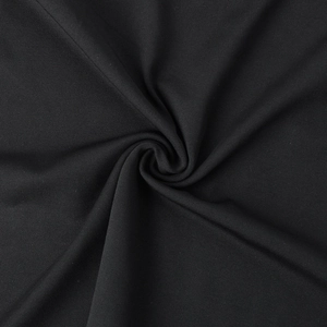 Macro shot of black knitted fabric showing fine texture, soft drape, and weaving patterns