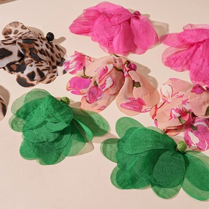 Detailed macro view of woven raffia floral earrings with faux pearls and lace textures