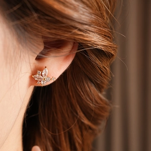 Gros plan d'une boucle d'oreille papillon plaquée or avec zircons clairs scintillants