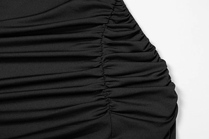 Close-up of ruched side detail and texture on a black slim fit long sleeve dress
