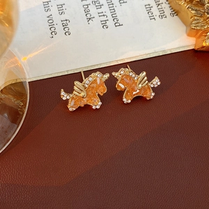 Nahaufnahme von Vintage-Einhorn-Ohrringen mit orangefarbenen Steinen und Kristallen