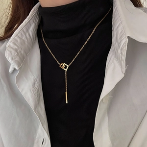 Detailed view of layered geometric square pendant necklace in 18k gold finish