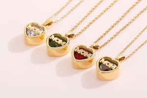 Detail of four golden heart necklaces with MOM engraving and colorful birthstones