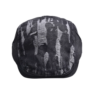 Detailed view of black washed denim beret with distressed torn edges and retro street style