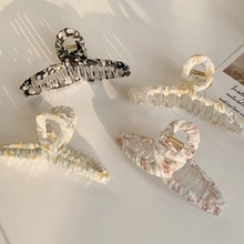 Flat lay of marble pattern hair clips in black, white, pink and yellow styles