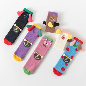 Detail of five pairs of coral fleece socks with cute cartoon ears and bow decorations