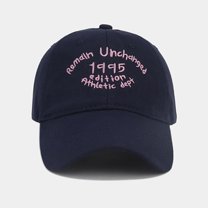 Dettaglio del ricamo rosa vintage su un berretto da baseball in cotone blu marino