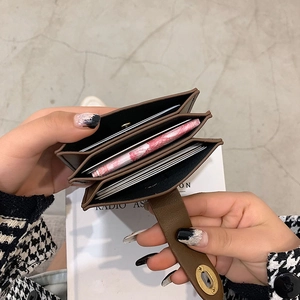 Καφέ δερμάτινο πορτοφόλι ακορντεόν με τρεις θήκες και χρυσό περιστροφικό κλείδωμα