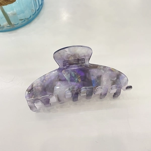 Detail view of purple marble acetate hair claw clip with golden and white swirls