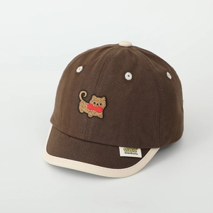 Détail de l'ours brodé et de l'étiquette sur la casquette marron pour enfants avec bordure