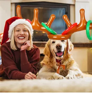 Inflatable reindeer antler toss game showing a woman playing with a dog by a fireplace