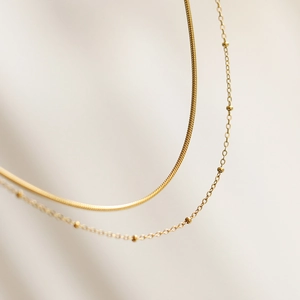Double layer 18K gold plated snake and satellite bead necklace on beige silk