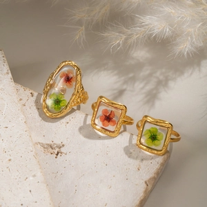 Gold vintage rings set with colorful dried flowers in resin, elegant nature style jewelry