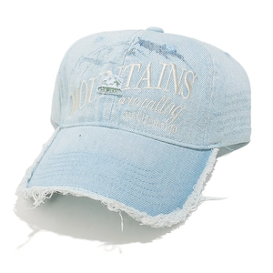 Close-up of embroidered mountain patch and distressed denim texture on baseball cap