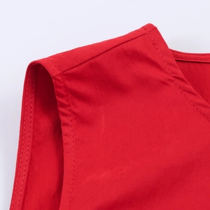 Détail de la couture d'épaule et du col sur le tissu d'une robe rouge sans manches