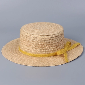 Detail of the flat top straw boater hat featuring a vibrant yellow woven ribbon bow