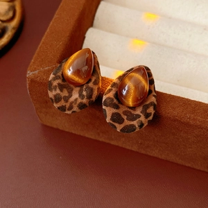 Detail view of teardrop cat eye stone and leopard print flocking on these fashion earrings