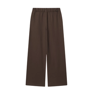 Detail of dark brown wide-leg trousers featuring a comfortable elastic waistband design