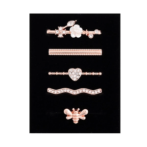 Detailed macro view of rose gold charms and bee studs set for silicone watch bands