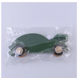 Détail d'une décoration de voiture en bois vert avec étoiles dorées et pompons en sachet