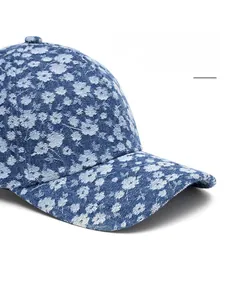 Detail view of denim baseball cap with floral pattern and wide curved brim design