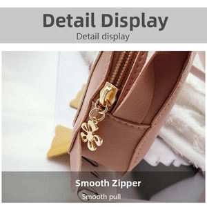 Close-up of smooth golden metal flower pendant and high-quality zipper on pink bag
