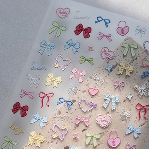 3D cartoon nail stickers with colorful bows, hearts and pretty lettering on stone display
