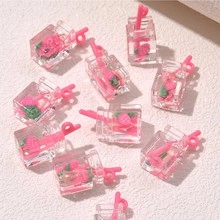 Close-up of pink miniature resin strawberry drink box pendants for DIY jewelry crafting