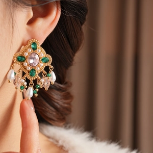 Gros plan sur les boucles d'oreilles vintage serties de diamants et de glands en perles