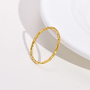 Macro detail of a minimalist gold thin ring featuring delicate bamboo textured facets