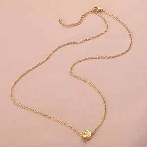 Golden starfish seashell pendant necklace with adjustable chain on pink fabric background