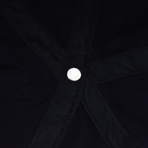 Detail of metal rivet reinforcement and sturdy stitching on black denim baseball cap