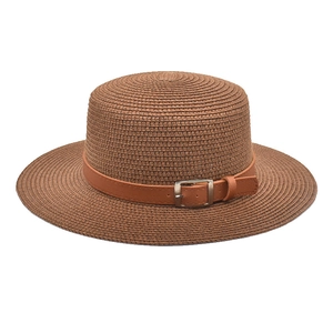 Detalle de sombrero de paja marrón con banda de imitación de cuero y hebilla metálica
