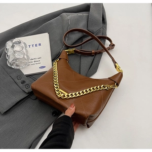 Detailed shot of brown quilted bucket bag with gold chain and leather shoulder strap
