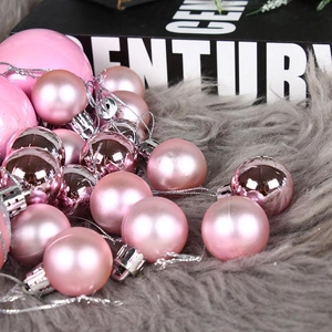Palline di Natale rosa e oro rosa su tappeto di pelliccia grigia per decoro festivo