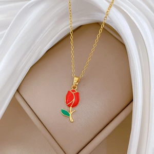 Detail of gold titanium steel necklace with a red tulip enamel pendant and crystals