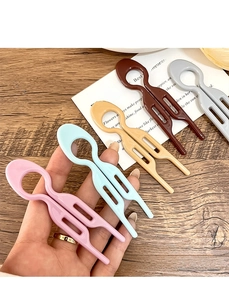 Set of five colorful U-shaped hair forks with geometric hollow design on wooden desk