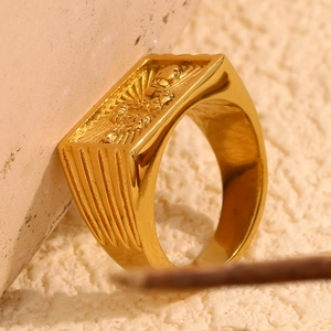 Detail of 18K gold-plated signet ring featuring a rectangular embossed religious motif