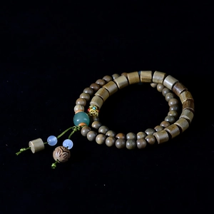 Detailed view of Verawood beaded bracelet with green jade and golden spacers on black background