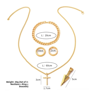 Detailed view of golden jewelry set with cross necklace, cuban bracelet, and rings