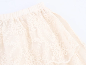 Detail of bohemian tiered lace skirt with elegant floral embroidery and elastic waist