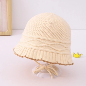 Close-up of knit baby sun hat with honeycomb texture and decorative braided straps