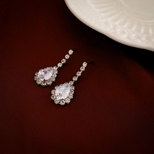 Macro detail of pear-shaped cubic zirconia earrings with pavé rhinestones in silver