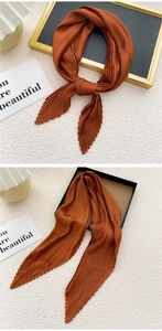 Close-up of caramel pleated scarf showing fine accordion folds and zigzag edges